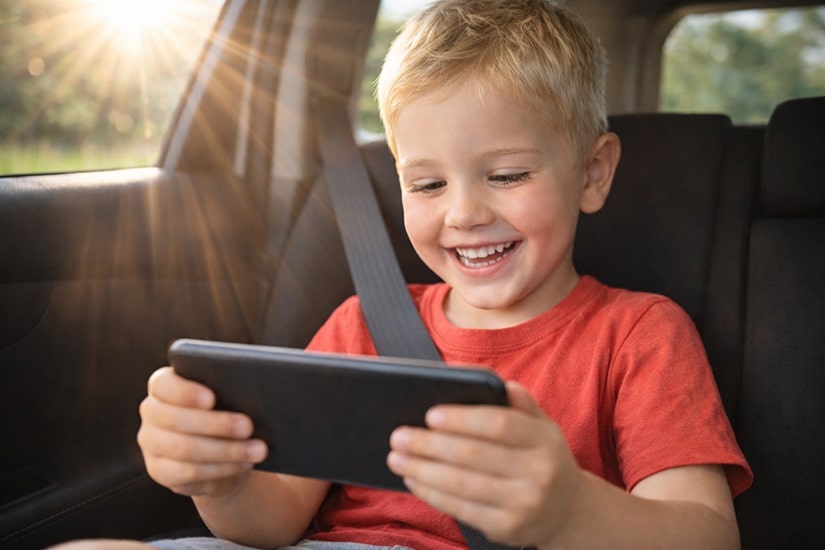 Boy using Smart Minis learning app in car